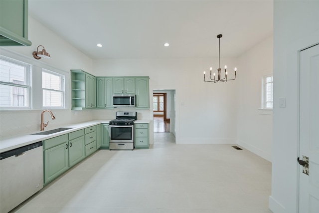 kitchen with open shelves, stainless steel appliances, visible vents, green cabinets, and a sink