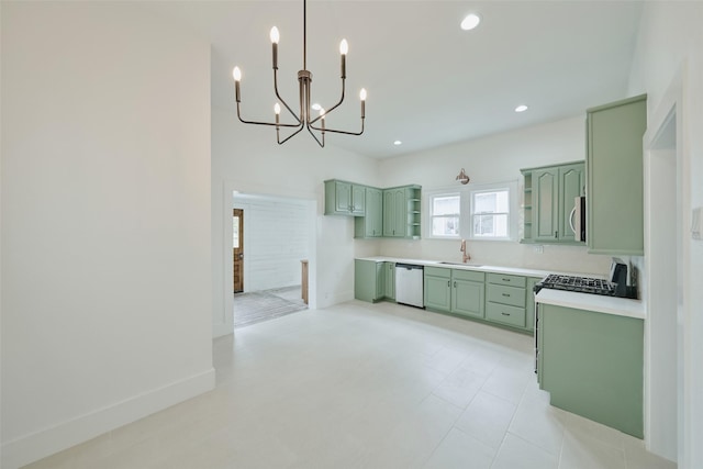 kitchen with backsplash, pendant lighting, sink, green cabinets, and appliances with stainless steel finishes