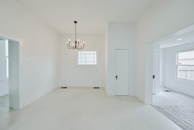 unfurnished room featuring visible vents and an inviting chandelier