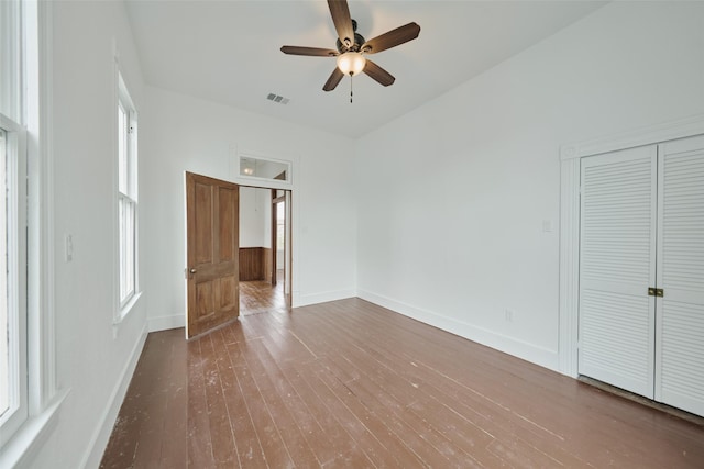 unfurnished bedroom with ceiling fan, wood-type flooring, and a closet