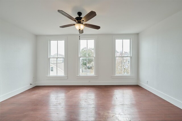 empty room with ceiling fan and hardwood / wood-style floors