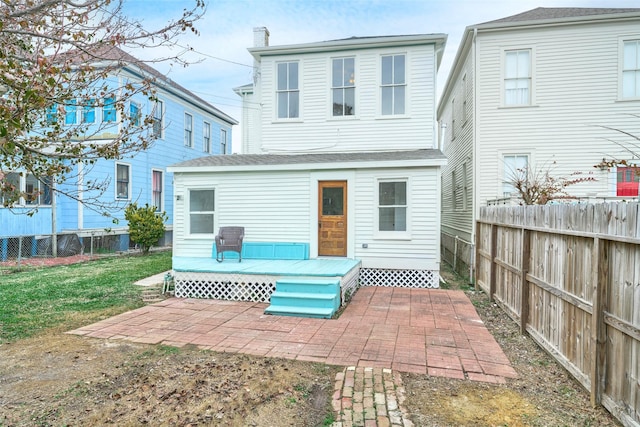 back of property with a patio area and a lawn