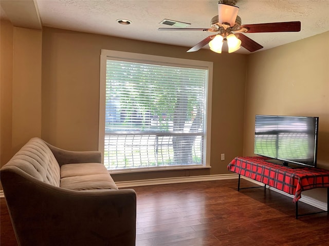 sitting room with a ceiling fan, wood finished floors, baseboards, and a textured ceiling