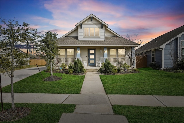 bungalow-style house featuring a porch and a yard