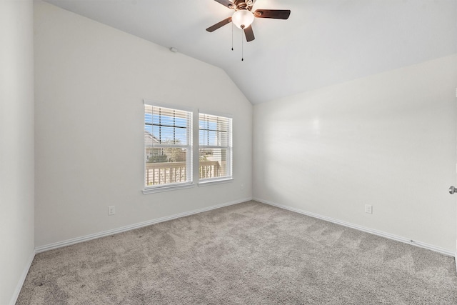 empty room with ceiling fan, light colored carpet, and vaulted ceiling