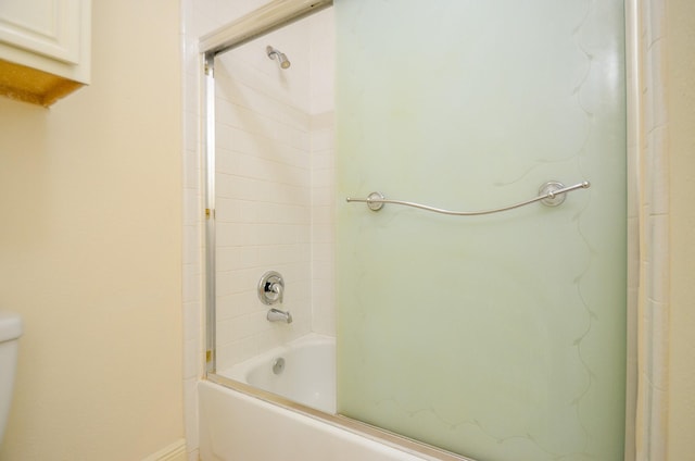 bathroom featuring bath / shower combo with glass door