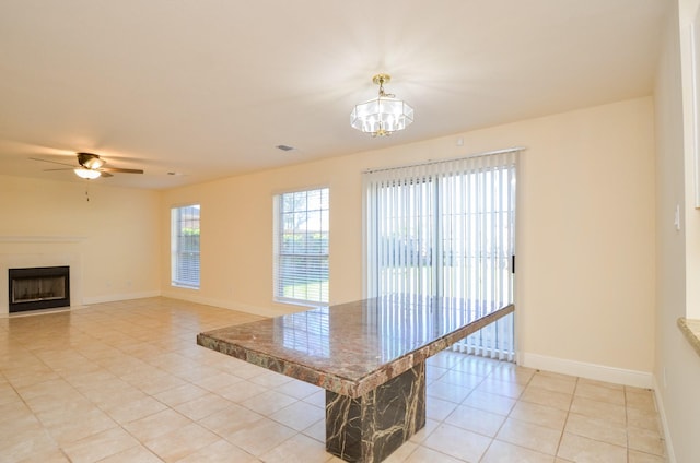 kitchen featuring ceiling fan, light tile patterned floors, and a breakfast bar area