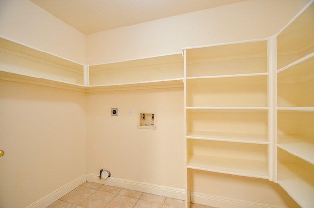 clothes washing area with electric dryer hookup, tile patterned floors, and washer hookup