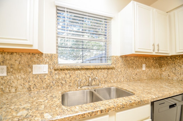 kitchen featuring decorative backsplash, light stone counters, white cabinetry, and sink