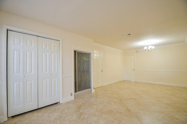 unfurnished bedroom featuring crown molding, a closet, and a chandelier