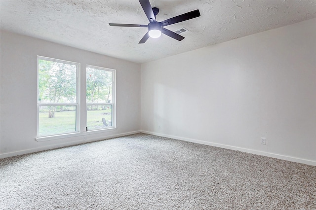 carpeted empty room featuring ceiling fan and a textured ceiling