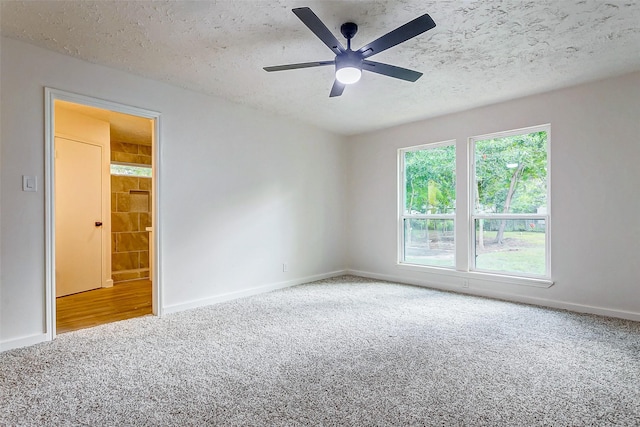 unfurnished room featuring carpet, ceiling fan, and a textured ceiling