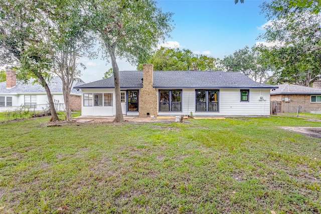 rear view of property with a yard