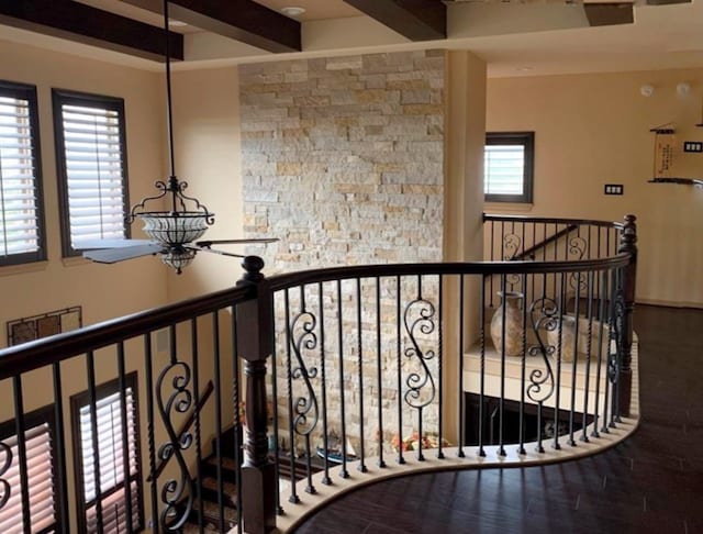 stairway featuring beam ceiling and a wealth of natural light