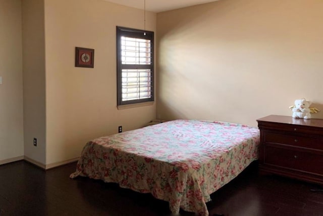 bedroom with dark wood-type flooring