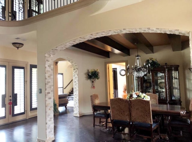 dining space with beamed ceiling, dark hardwood / wood-style floors, an inviting chandelier, and french doors