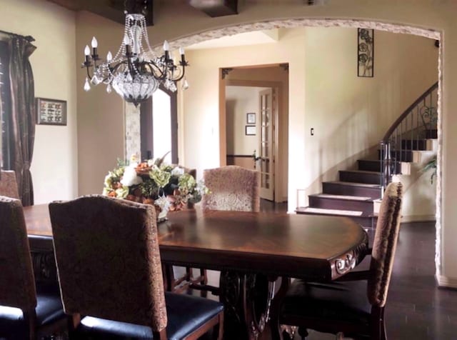 dining area with dark hardwood / wood-style flooring, a chandelier, and french doors