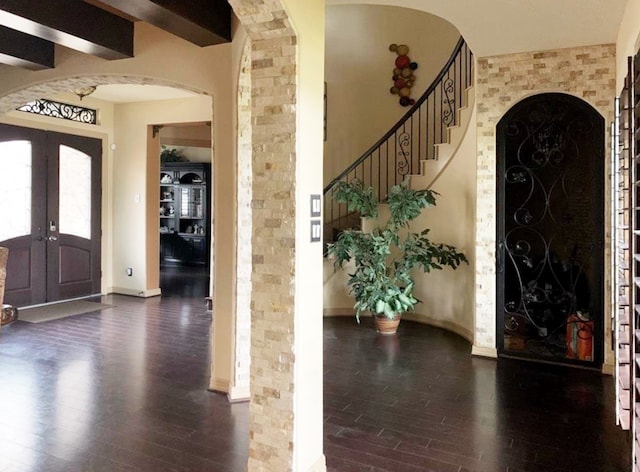 foyer entrance featuring beamed ceiling, french doors, and dark hardwood / wood-style floors