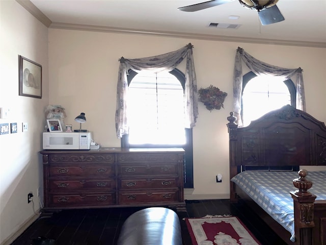 bedroom with dark hardwood / wood-style floors, ceiling fan, and crown molding