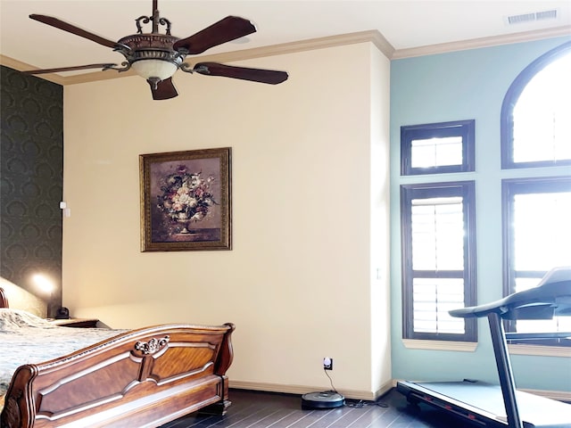 bedroom with dark hardwood / wood-style flooring, ceiling fan, and crown molding