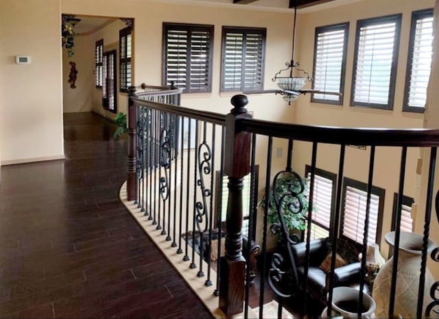 hallway with ornamental molding and dark wood-type flooring