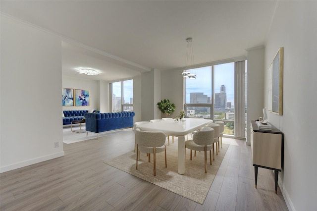 dining space featuring light hardwood / wood-style floors, an inviting chandelier, and expansive windows