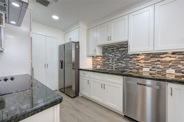 kitchen with dark stone countertops, white cabinetry, sink, and appliances with stainless steel finishes