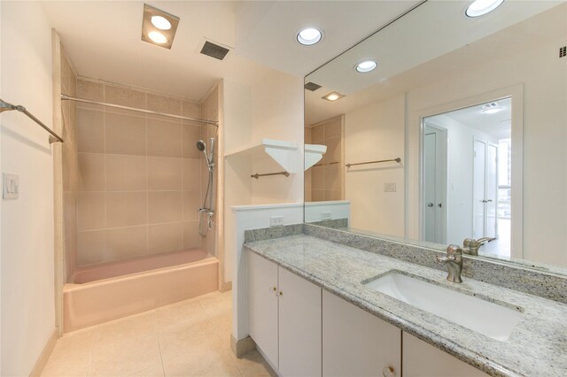 bathroom featuring tile patterned floors, vanity, and tiled shower / bath combo