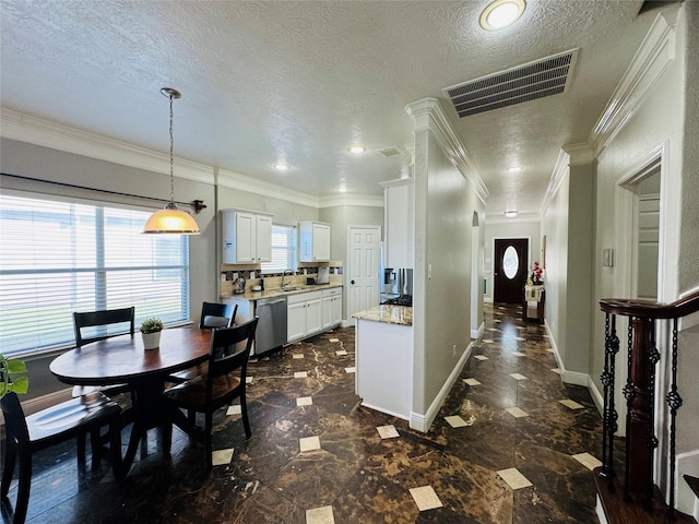 interior space featuring white cabinets, light stone counters, a textured ceiling, dishwasher, and hanging light fixtures