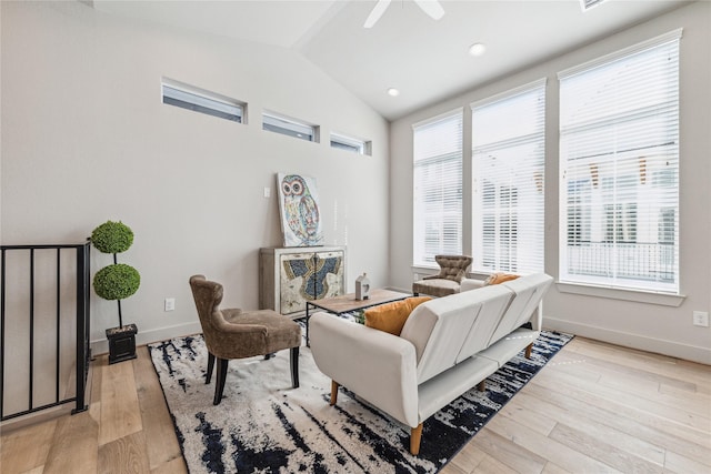 living room featuring ceiling fan, light hardwood / wood-style flooring, and lofted ceiling