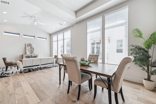 dining area with light wood-type flooring, vaulted ceiling, and ceiling fan