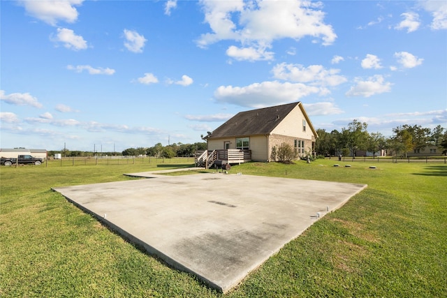 exterior space with basketball hoop, a rural view, and a deck