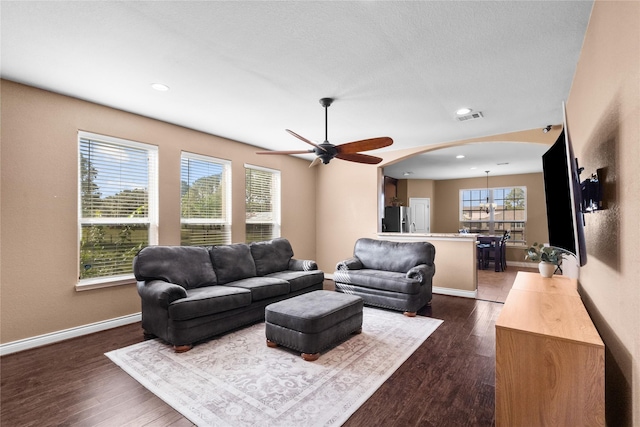 living room with ceiling fan and dark hardwood / wood-style floors