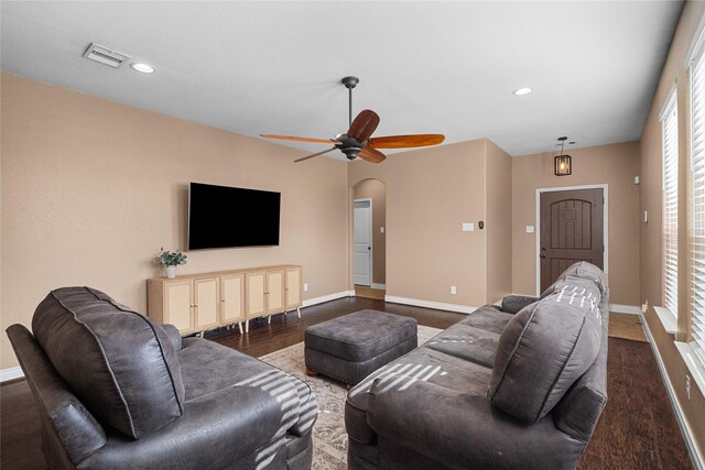 living room featuring ceiling fan and dark wood-type flooring