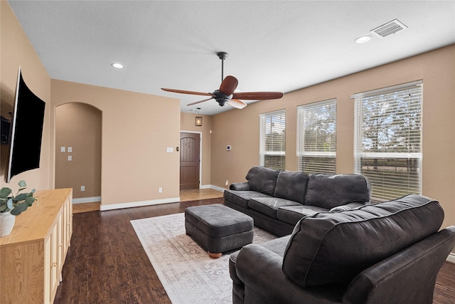 living room with ceiling fan and dark hardwood / wood-style flooring