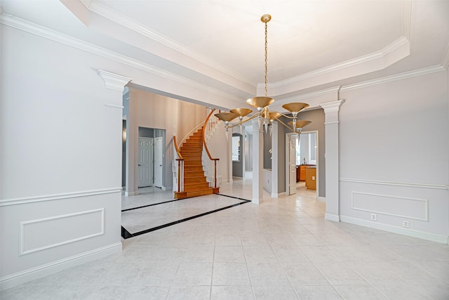 tiled spare room with a tray ceiling, ornamental molding, and a chandelier