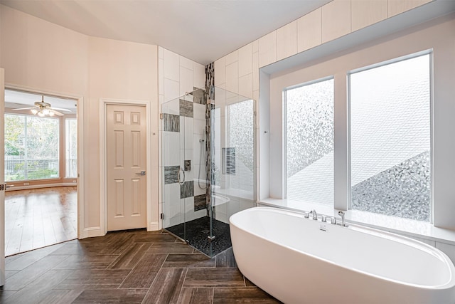 bathroom with ceiling fan, parquet floors, and shower with separate bathtub