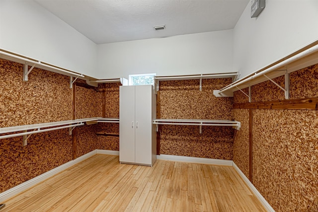 walk in closet with hardwood / wood-style floors