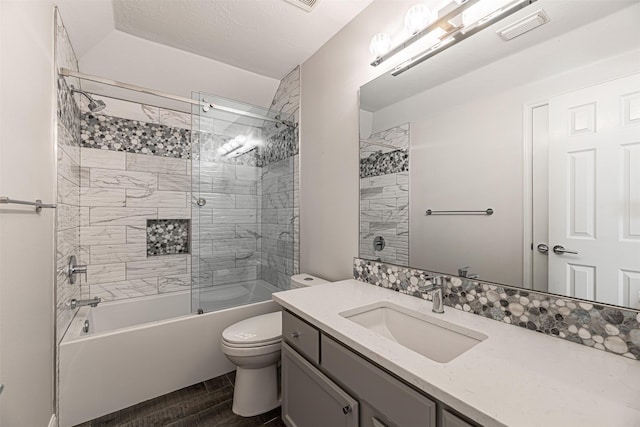 full bathroom with toilet, tiled shower / bath combo, and vanity