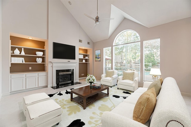 living room featuring ceiling fan, a premium fireplace, light tile patterned floors, high vaulted ceiling, and built in shelves