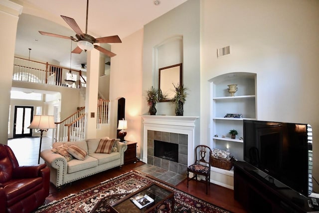 3803 Dewalt Way, Missouri City, TX 77459 - living room with built in shelves, ceiling fan, a high ceiling, dark hardwood / wood-style floors, and a tiled fireplace