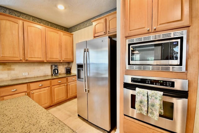 3803 Dewalt Way, Missouri City, TX 77459 - kitchen featuring backsplash, light stone counters, stainless steel appliances, and light brown cabinetry