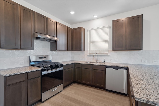 kitchen featuring light stone countertops, dark brown cabinets, stainless steel appliances, sink, and light hardwood / wood-style flooring