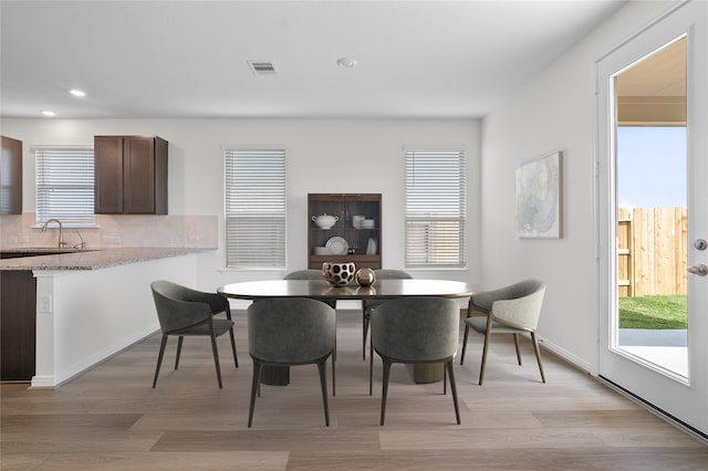 dining area with light hardwood / wood-style flooring and sink