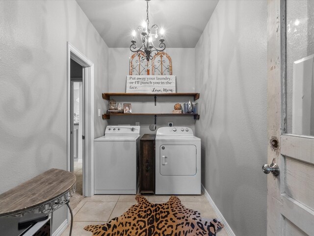 laundry room featuring a notable chandelier, washing machine and dryer, and light tile patterned floors