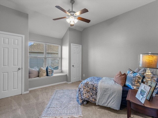 carpeted bedroom with ceiling fan and vaulted ceiling