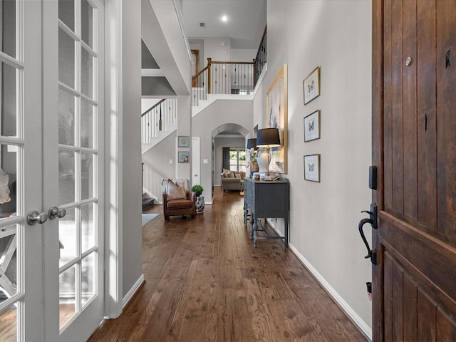 foyer with french doors, a towering ceiling, and dark hardwood / wood-style floors