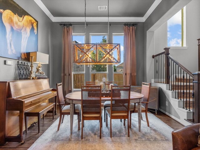 dining room with hardwood / wood-style flooring, plenty of natural light, and ornamental molding