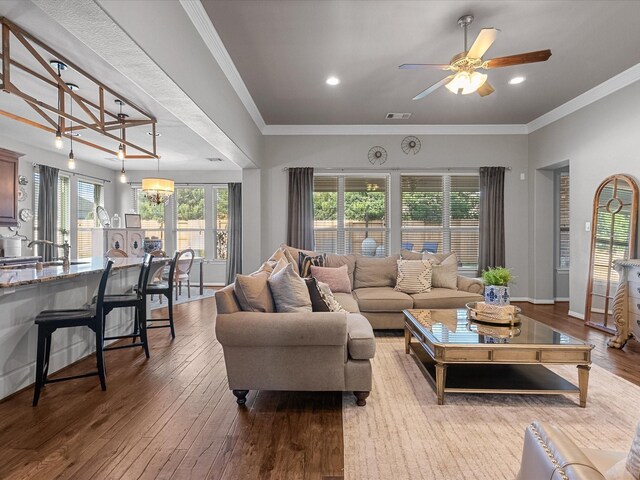 living room featuring ceiling fan, wood-type flooring, and crown molding