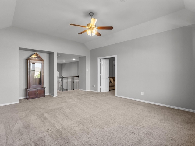 unfurnished living room with ceiling fan, light colored carpet, and vaulted ceiling